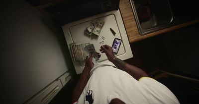 a person laying on a counter with a cell phone