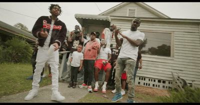 a group of people standing in front of a house