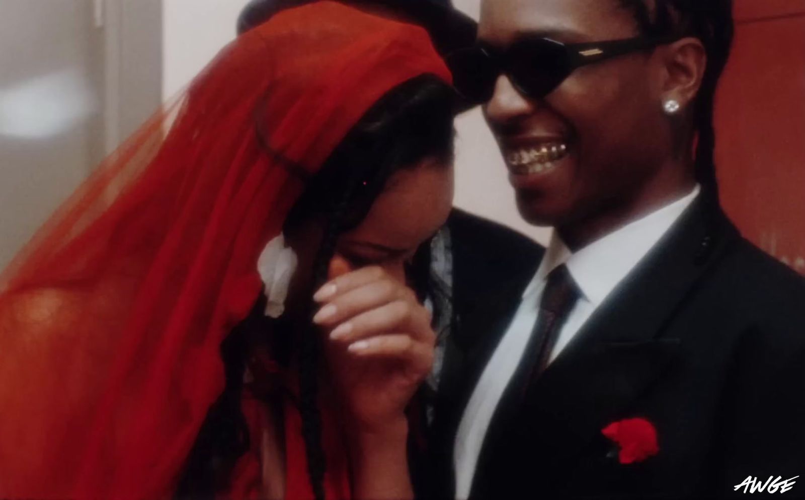 a man in a suit and tie standing next to a woman in a red dress