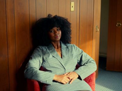 a woman sitting on a red chair in a room