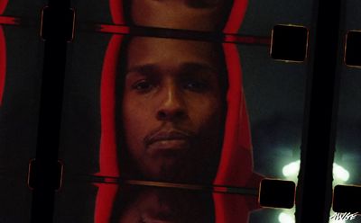 a man in a red hoodie is reflected in a mirror