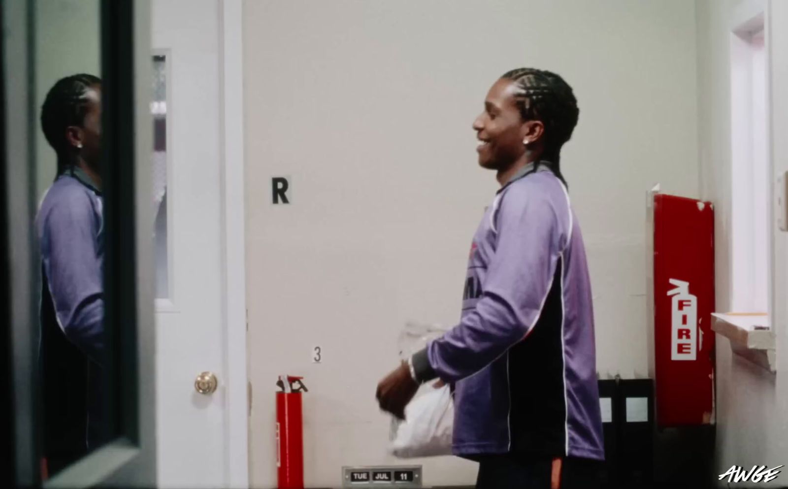 a man standing in front of a mirror holding a bag