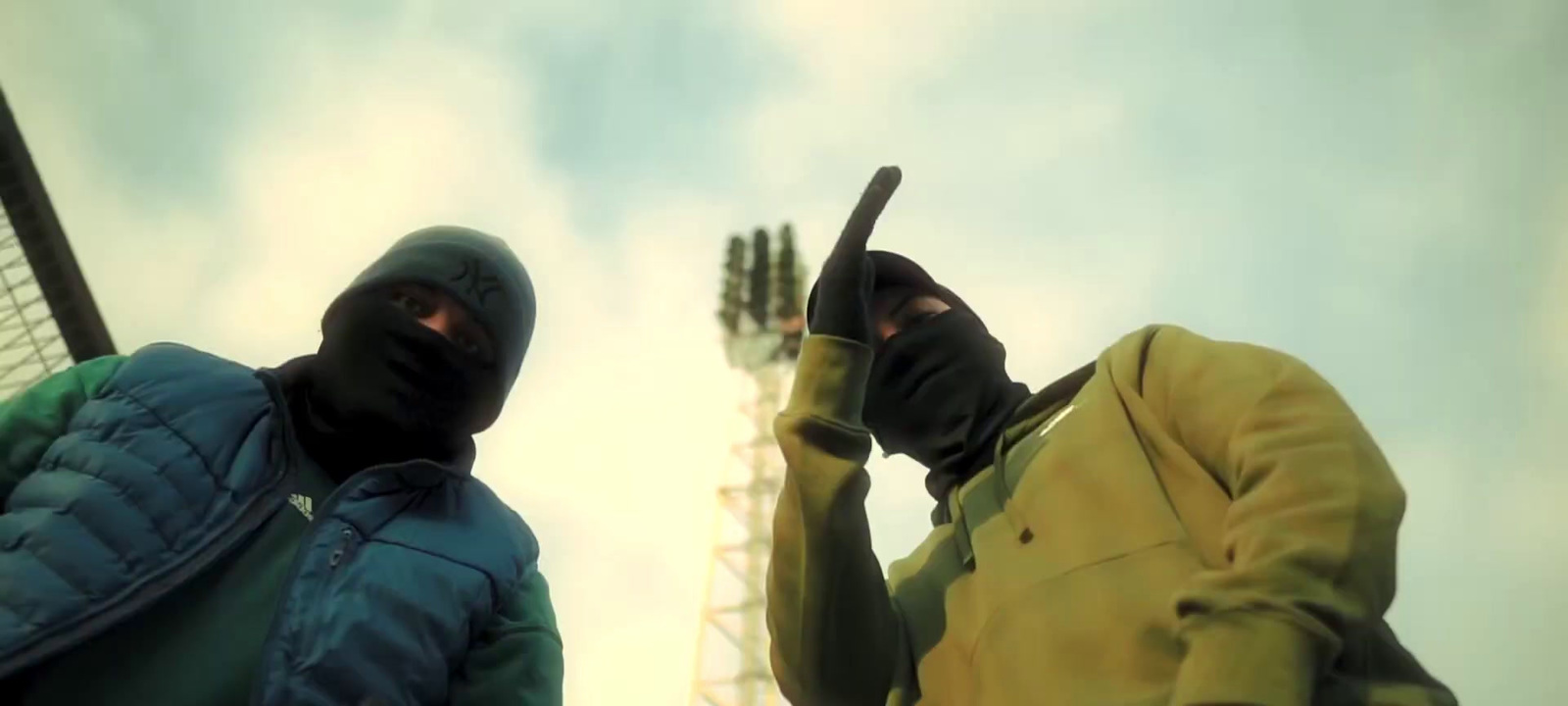 two people in black and yellow jackets holding tennis rackets