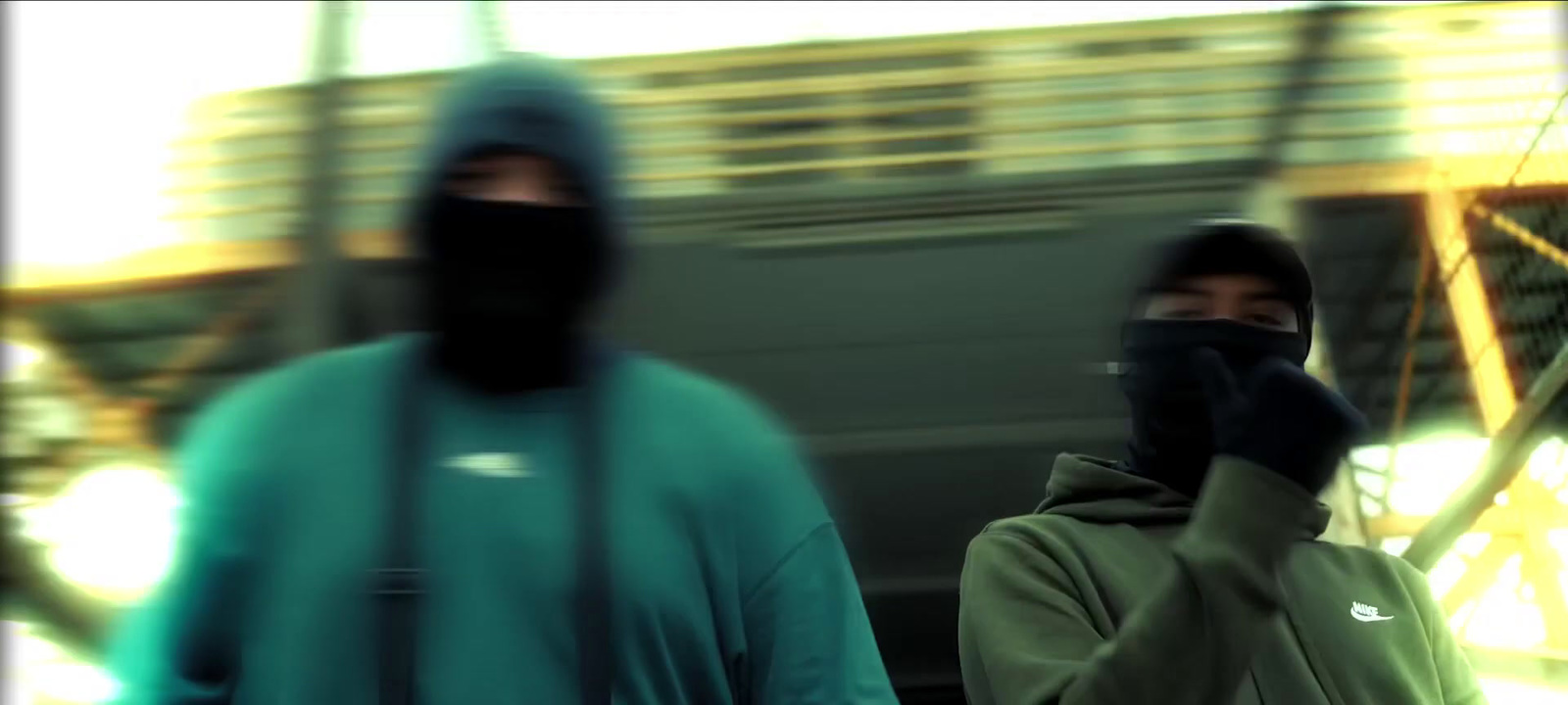 two men wearing face masks walking down a street