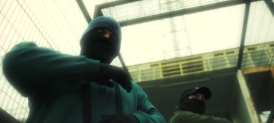 a man in a green hoodie holding a baseball bat