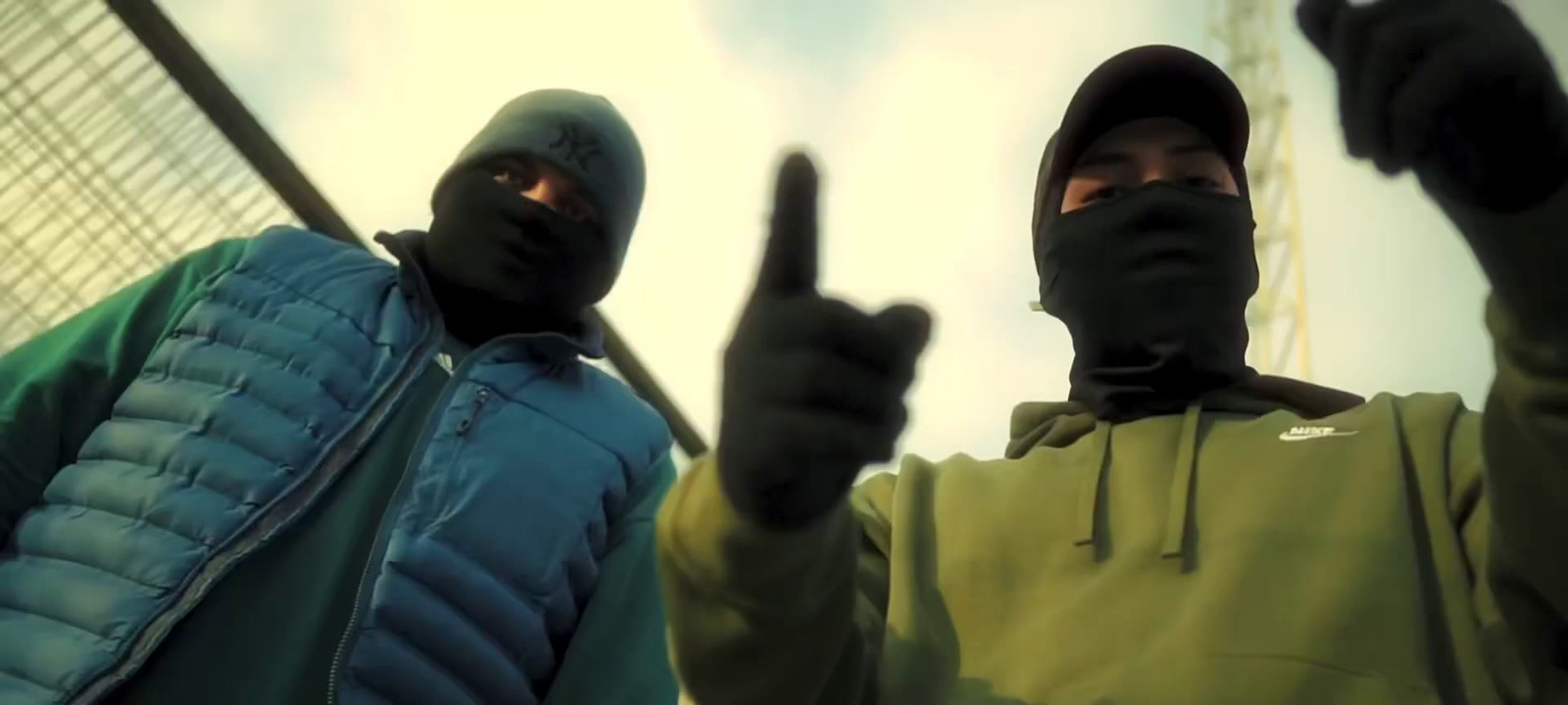 two men wearing black hoodies and holding up their fingers