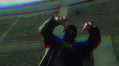 a man in a black jacket holding a rainbow ball