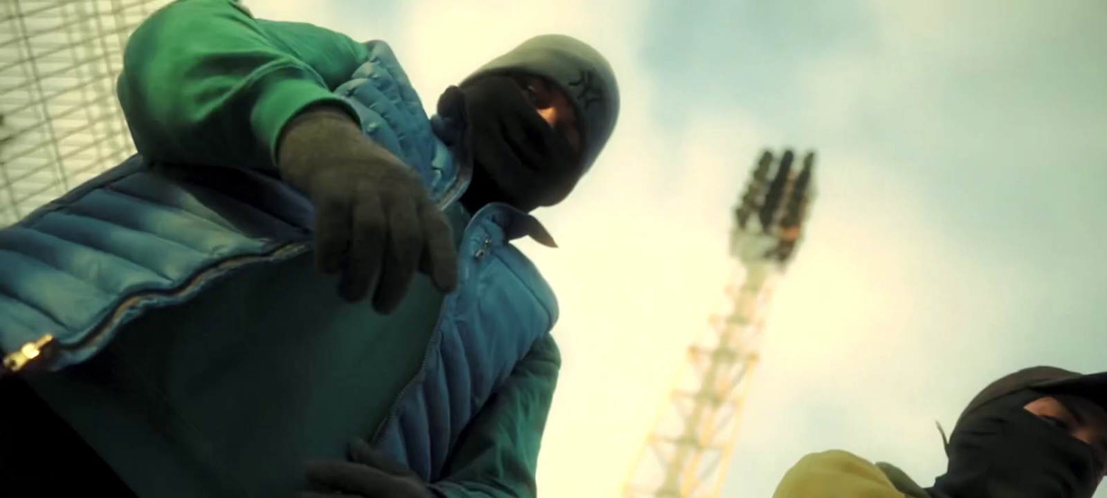 a man in a green jacket standing next to another man in a yellow jacket