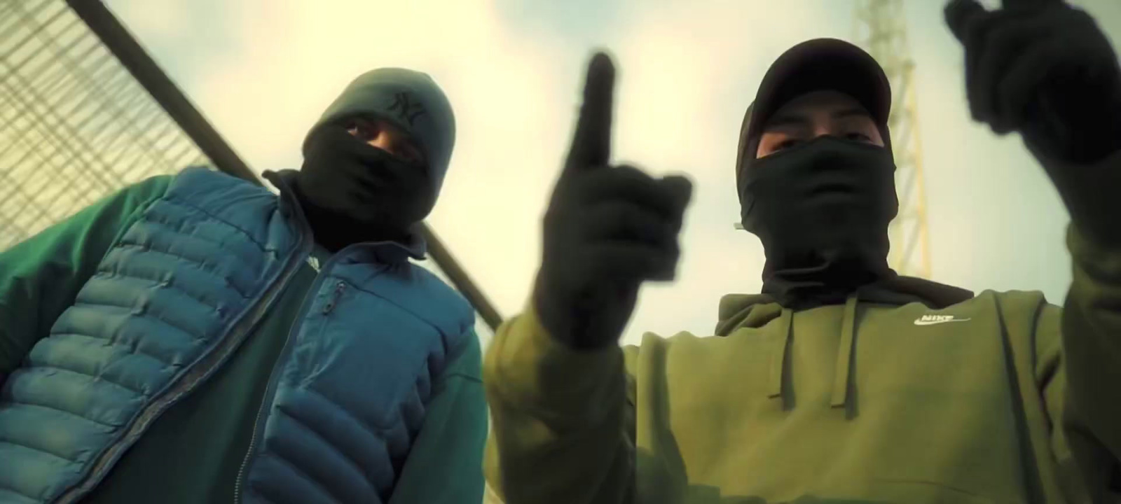 two men wearing black hoodies and holding up their fingers