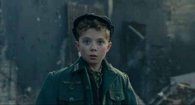 a young boy in a green coat and hat