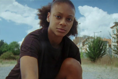 a woman sitting on the ground in front of a house