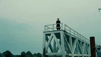 a man standing on top of a white bridge