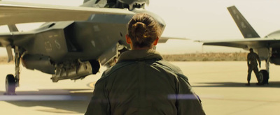 a man standing in front of a fighter jet