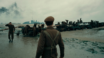 a group of men walking across a wet beach