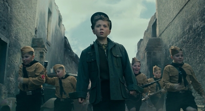 a boy in a military uniform is surrounded by other boys