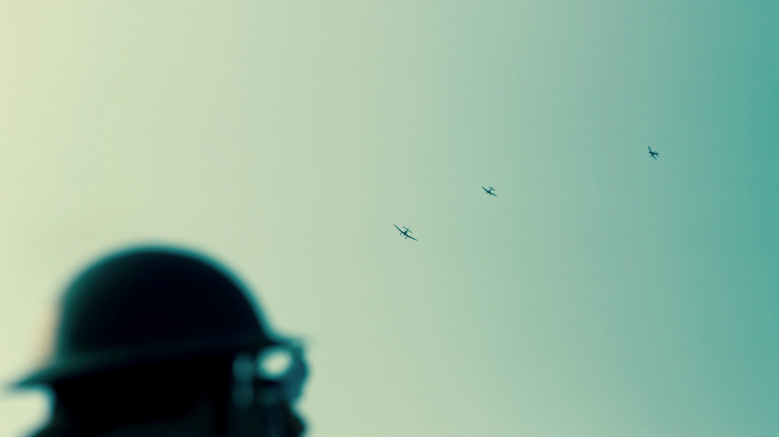 a man with a gun looking at a group of birds in the sky