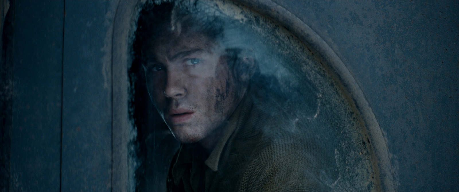 a man looking out of a round window