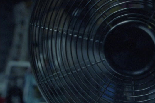 a close up of a metal fan in a room