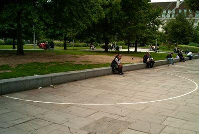 a group of people sitting on the side of a road