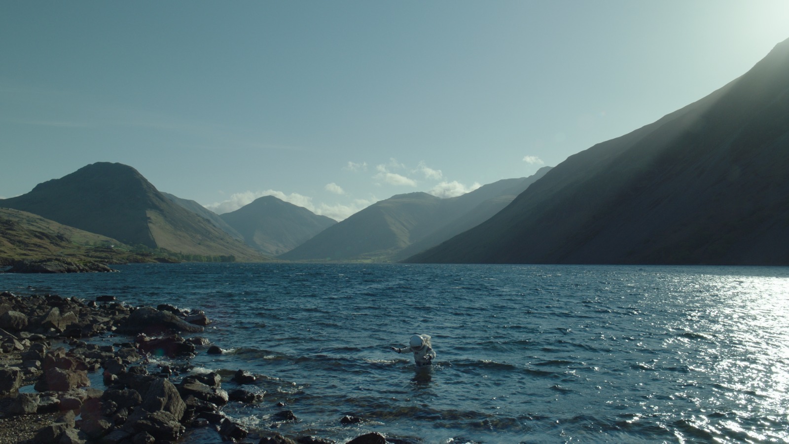 a body of water with mountains in the background