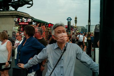 a man wearing a face mask in front of a crowd of people