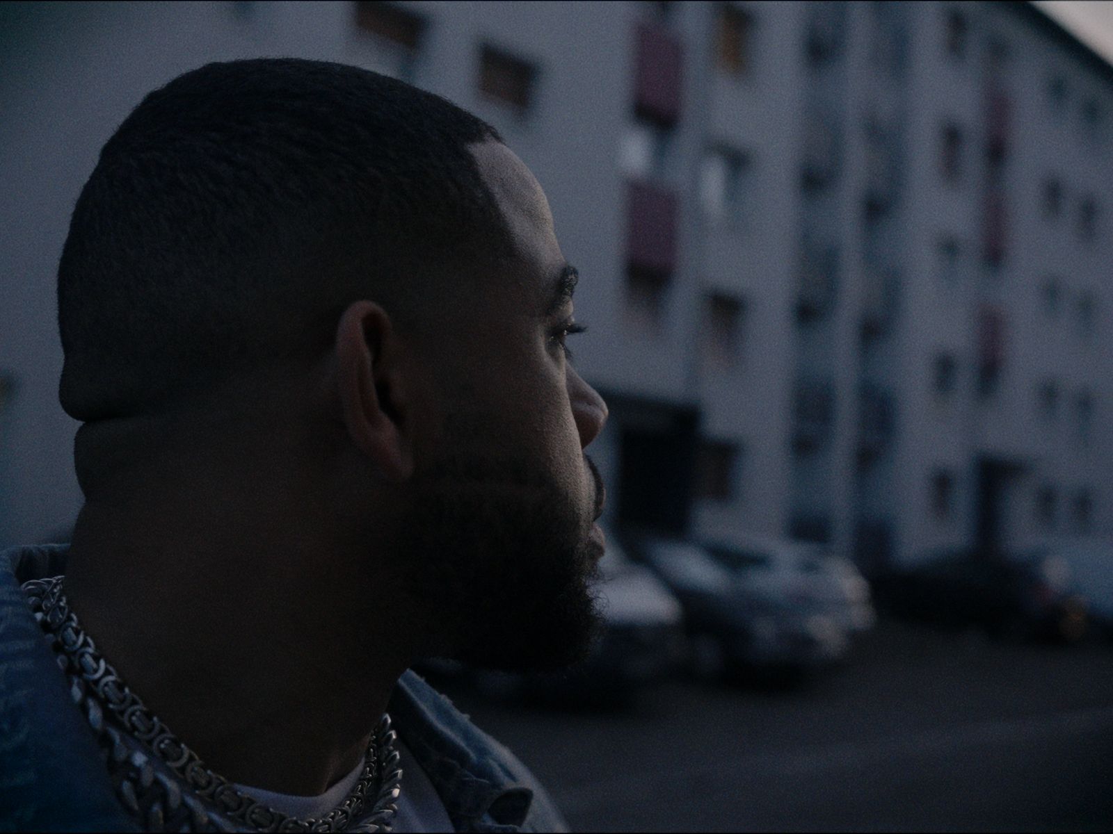 a man with a beard standing in front of a building