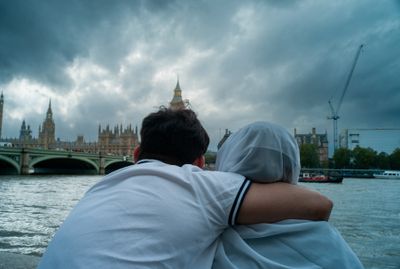 a man and a woman are looking at the water