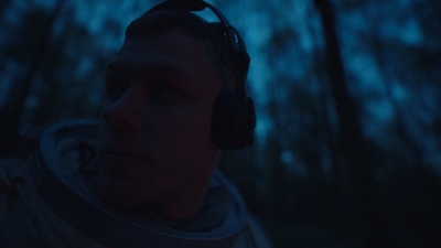 a man wearing headphones in a forest