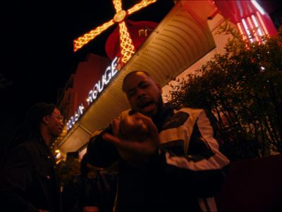 a man holding a hot dog in front of a building