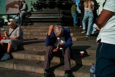 a man sitting on a set of steps next to a crowd of people