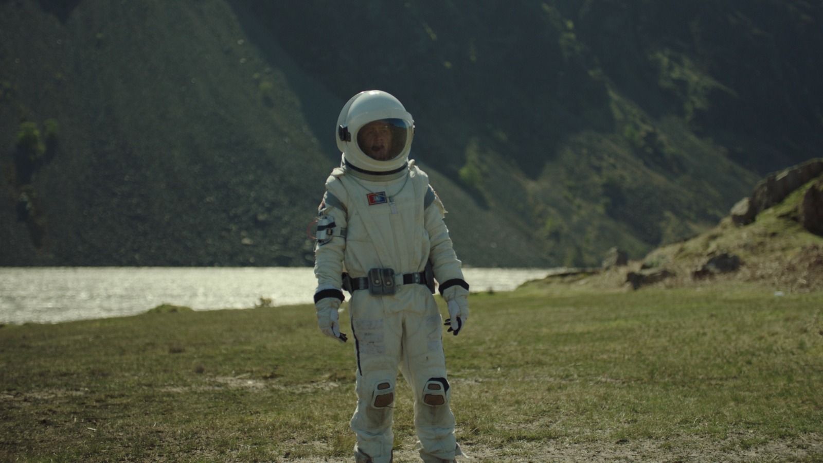 a man in a space suit standing in a field