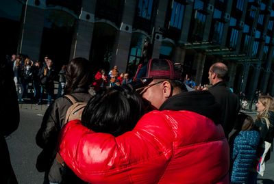 a man in a red jacket hugging a woman in a red jacket