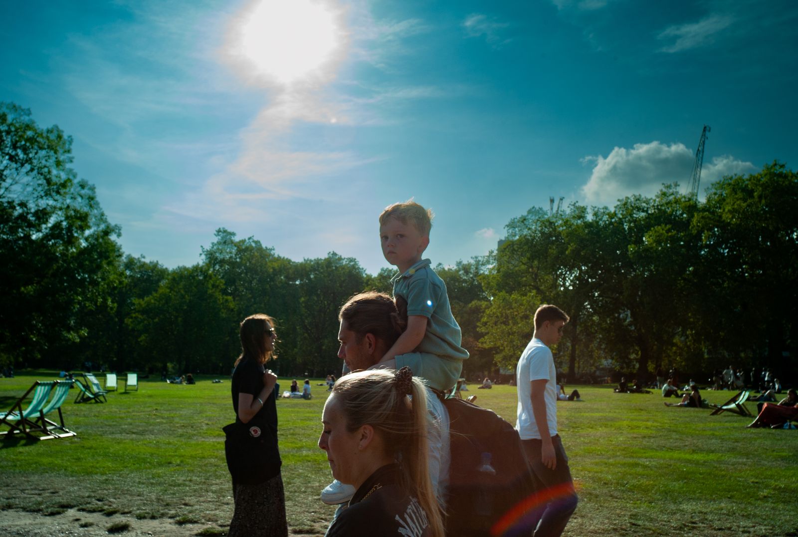 a young boy sitting on the back of a woman's shoulders