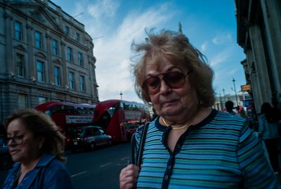 a woman in a striped shirt is walking down the street