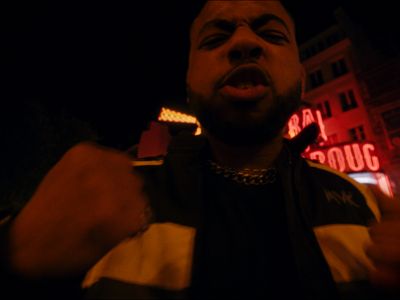 a man standing in front of a neon sign