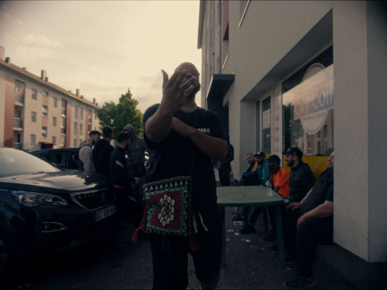 a man standing in front of a building while covering his face