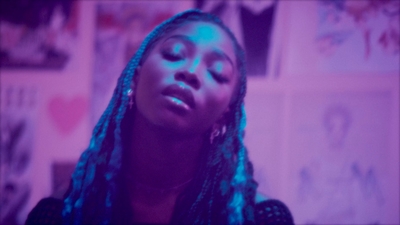 a woman with long braids looking up at the sky