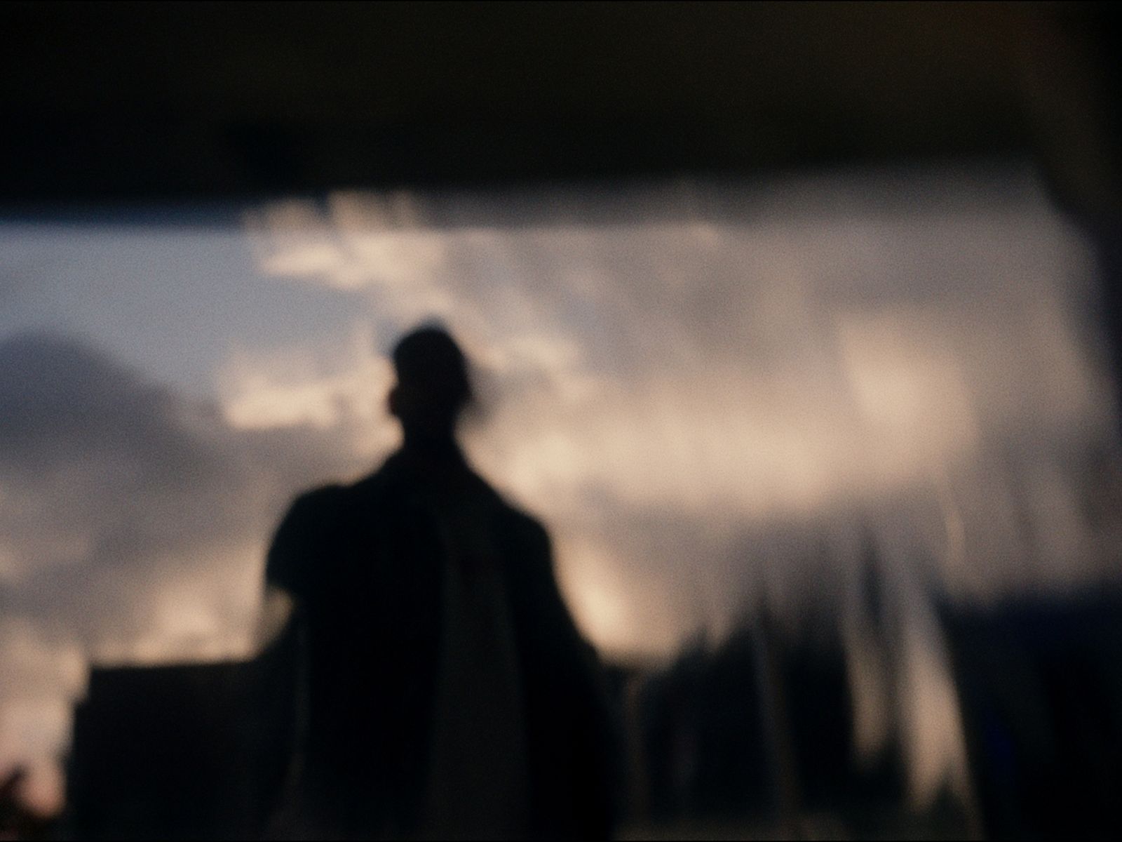 a blurry image of a man standing in front of a window