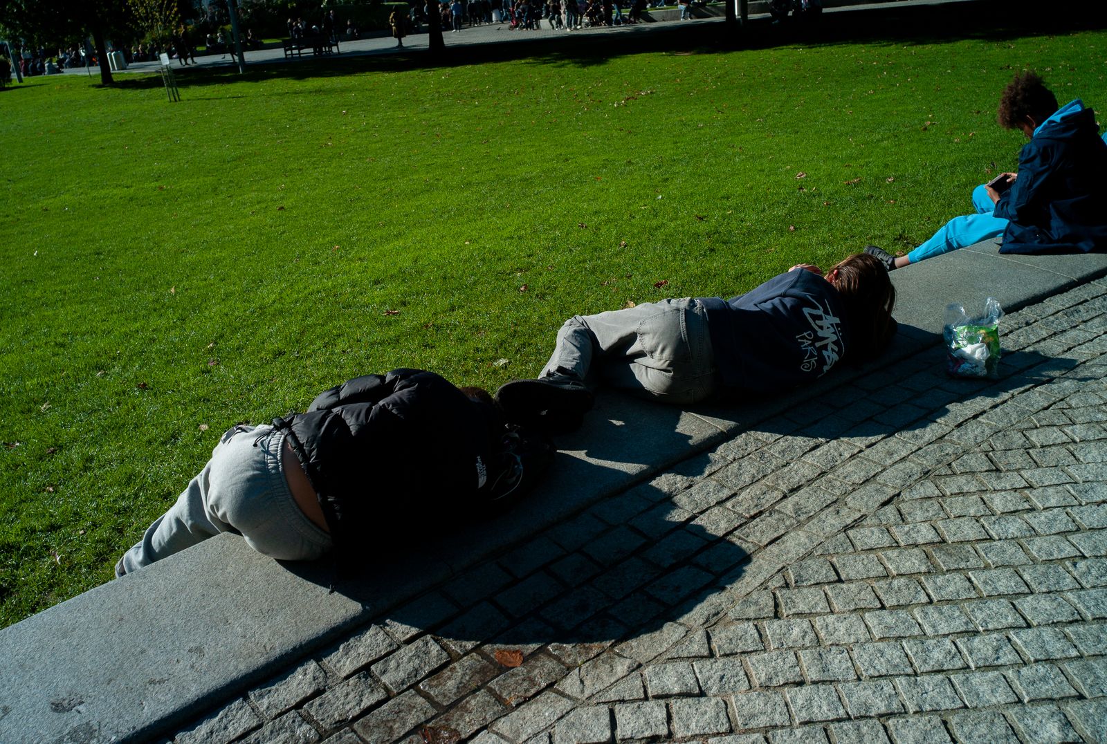 a couple of people laying on top of a sidewalk