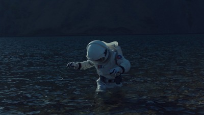 a man in a space suit wading in a body of water