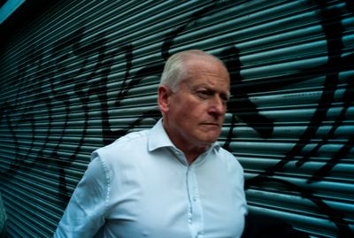 a man standing in front of a wall with graffiti on it