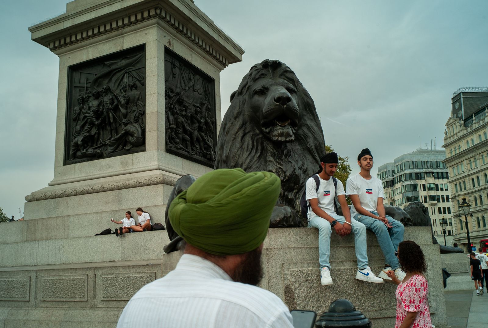 a group of people sitting on a stone lion statue