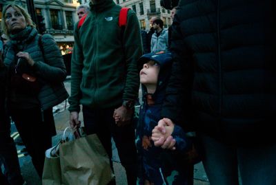 a group of people walking down a street holding hands