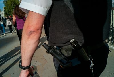 a police officer walking down the street with a gun in his hand