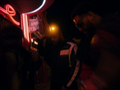 a group of people standing outside of a building at night