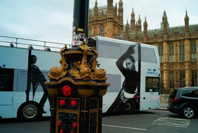 a double decker bus driving down a street next to a tall building