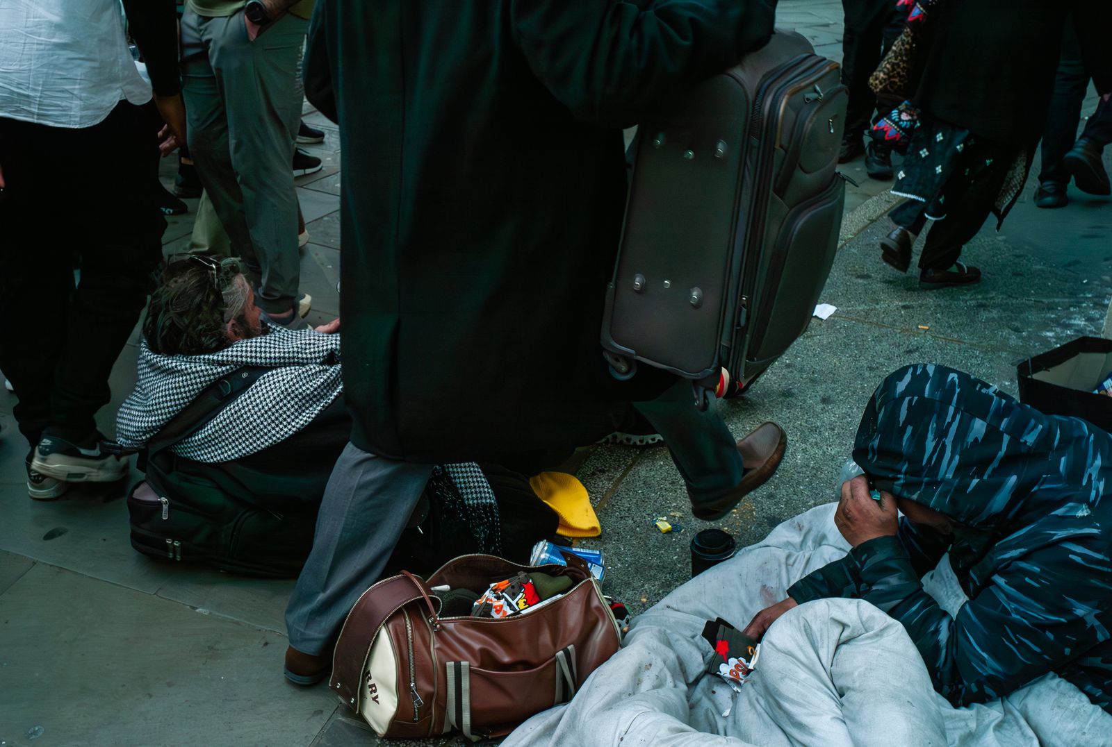 a group of people standing around a man laying on the ground