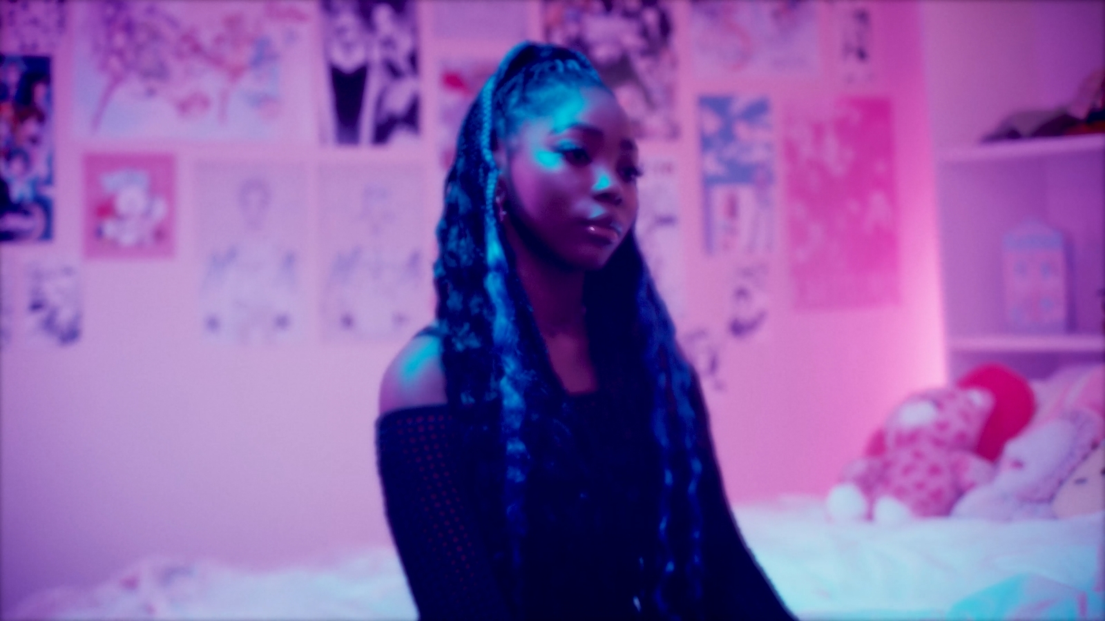 a woman with long braids sitting on a bed