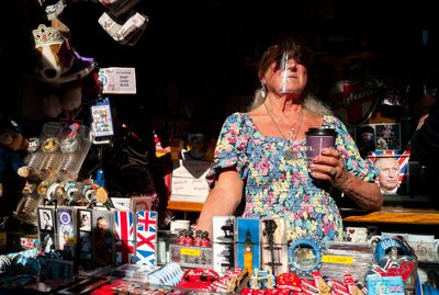 a woman holding a cup in front of a table full of items