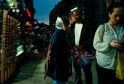 a group of people walking down a street at night